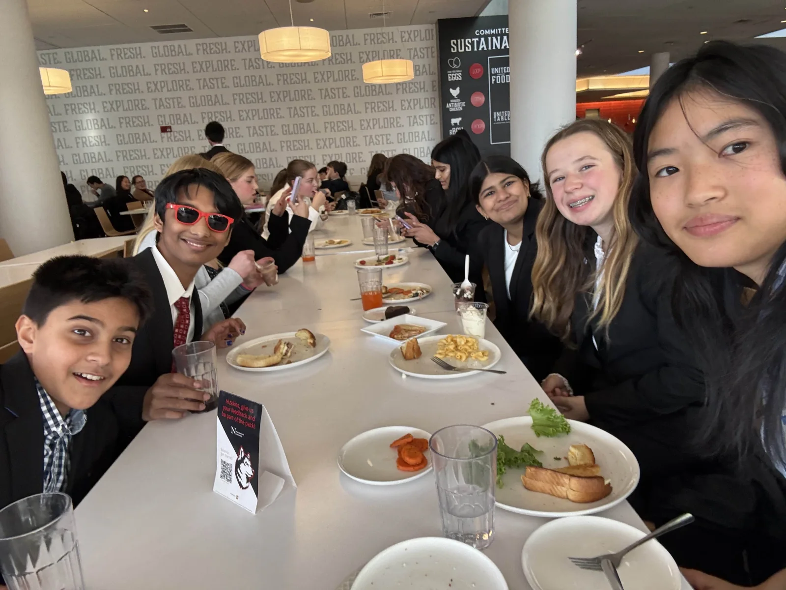 MUNSDG delegates smiling together over lunch during a conference
